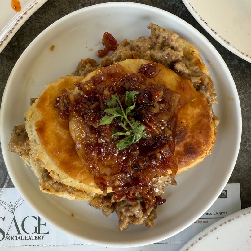 Sage Social Eatery's biscuits and gravy topped with caramelized onions and a sprig of parsley.